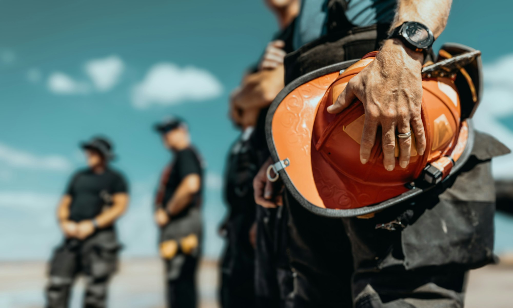 Construction worker holding hard hat with colleagues