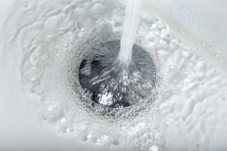 tap water flowing into stainless steel drain